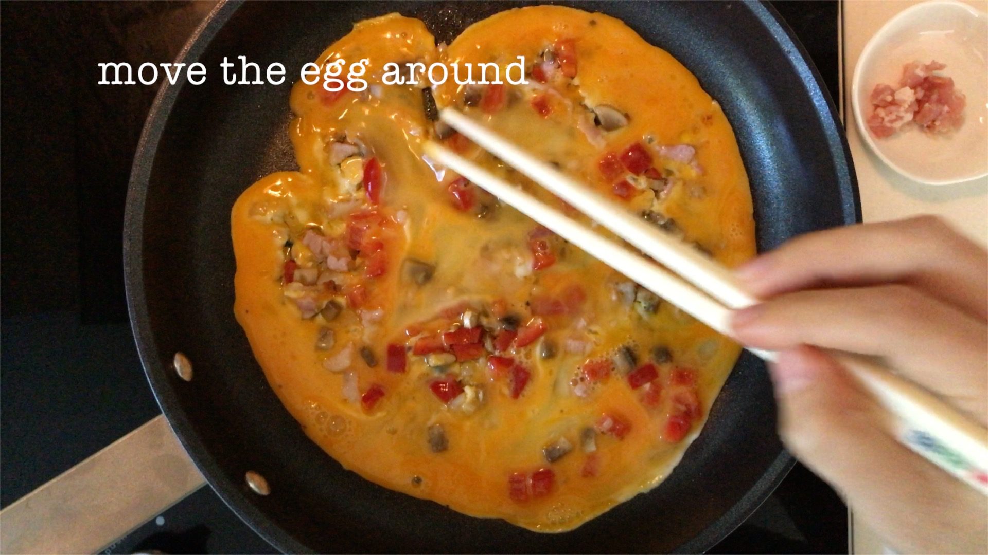 gently moving the egg mixture around to mix with the bacon, shallot, mushroom and red bell pepper