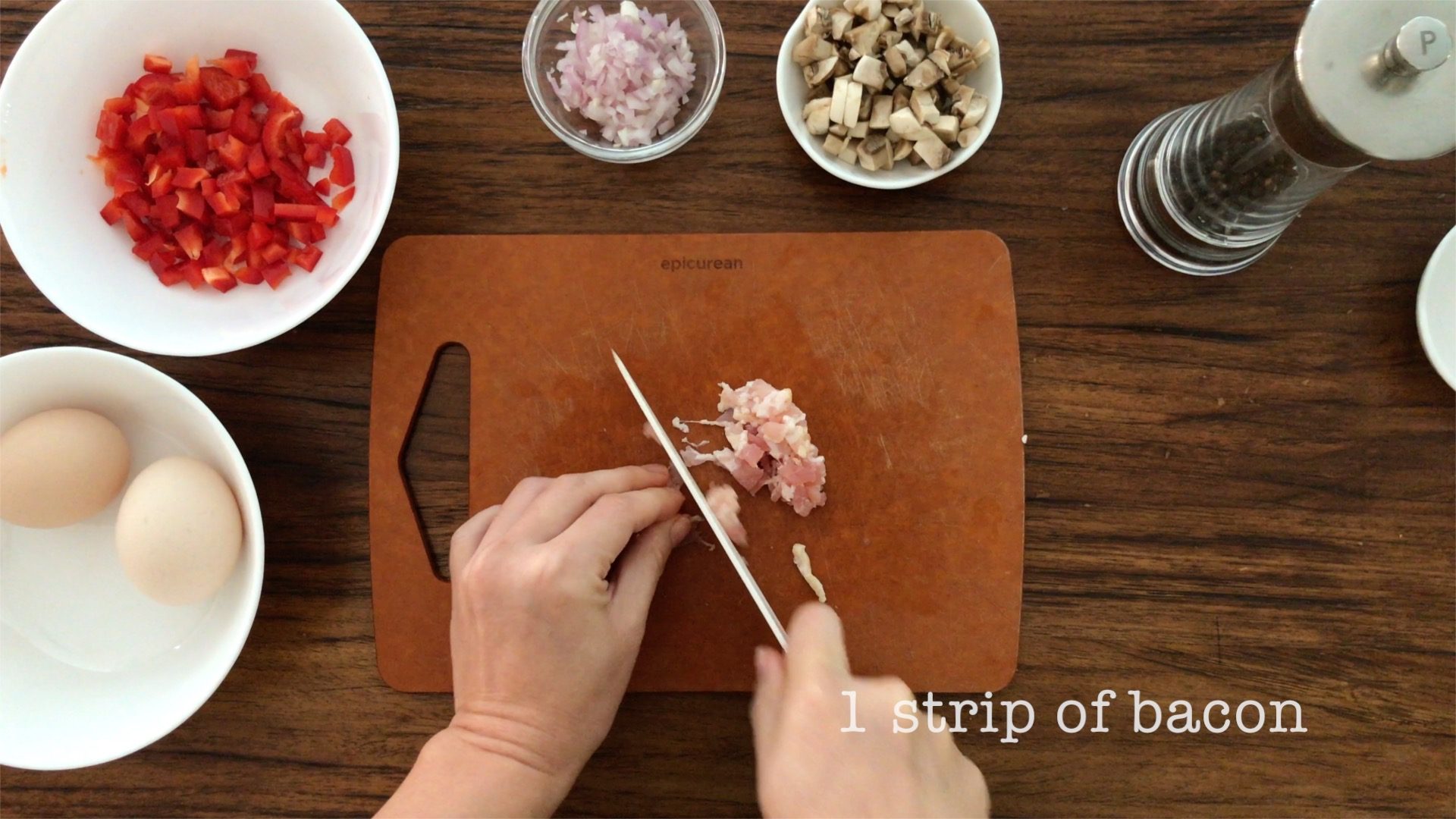 cutting a strip of bacon into small pieces