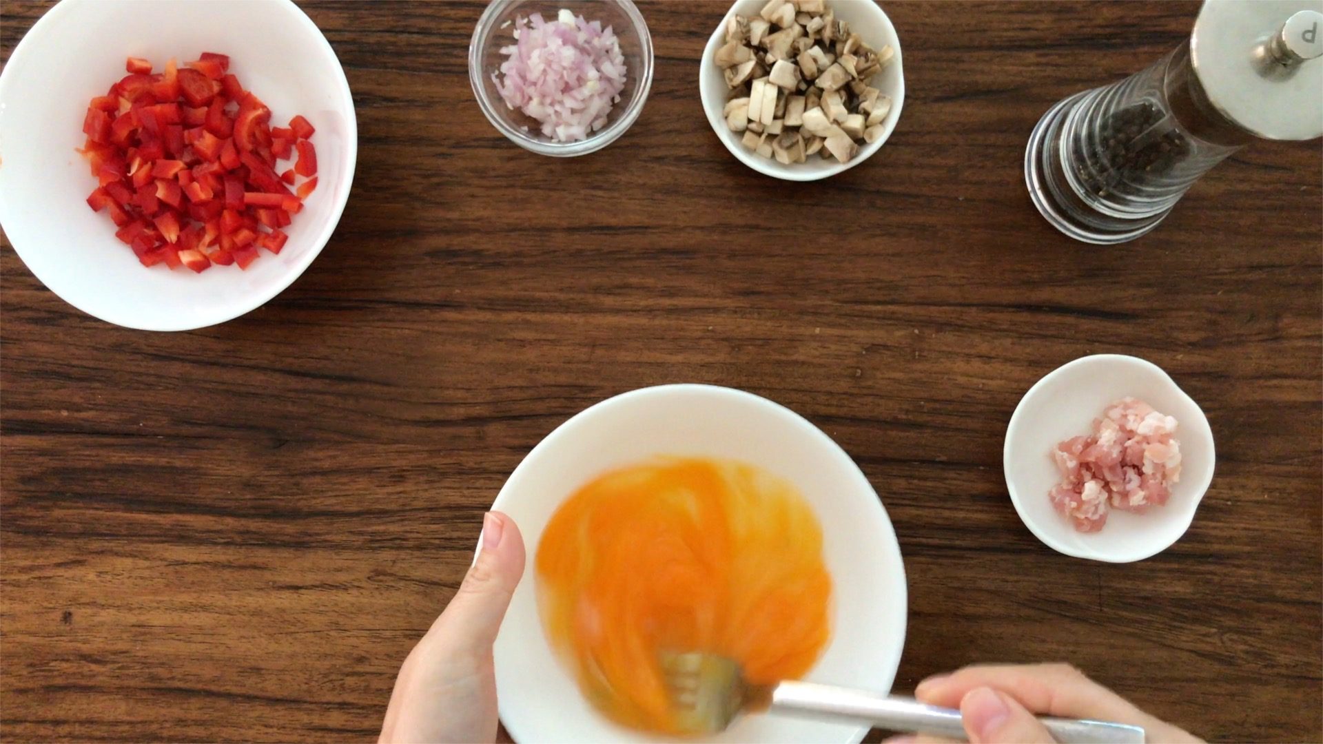 beating two eggs in a white bowl with a fork
