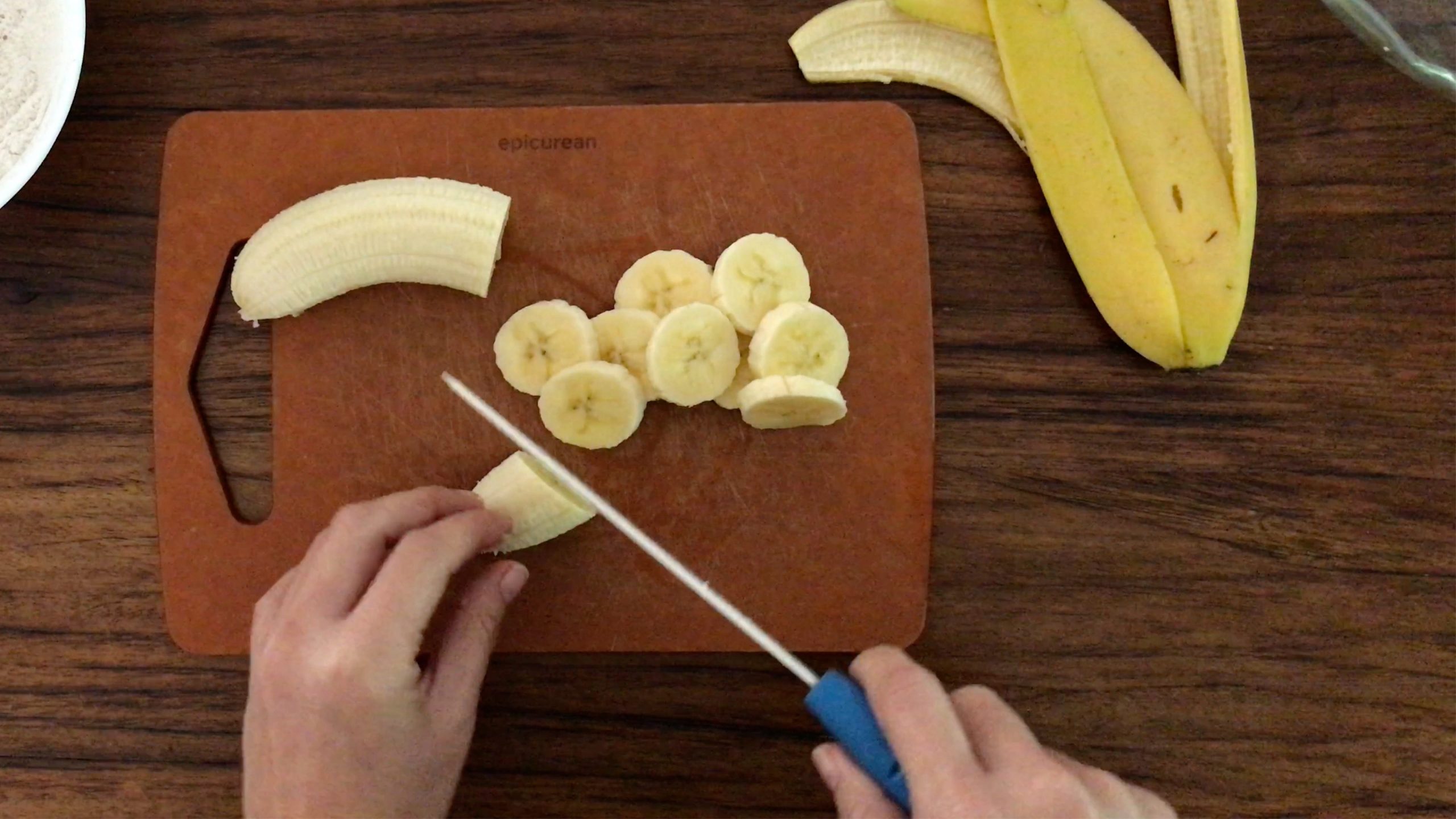 slicing a ripe banana on a chopping board
